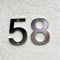Black house numbers 5 and 8 against white stucco background.