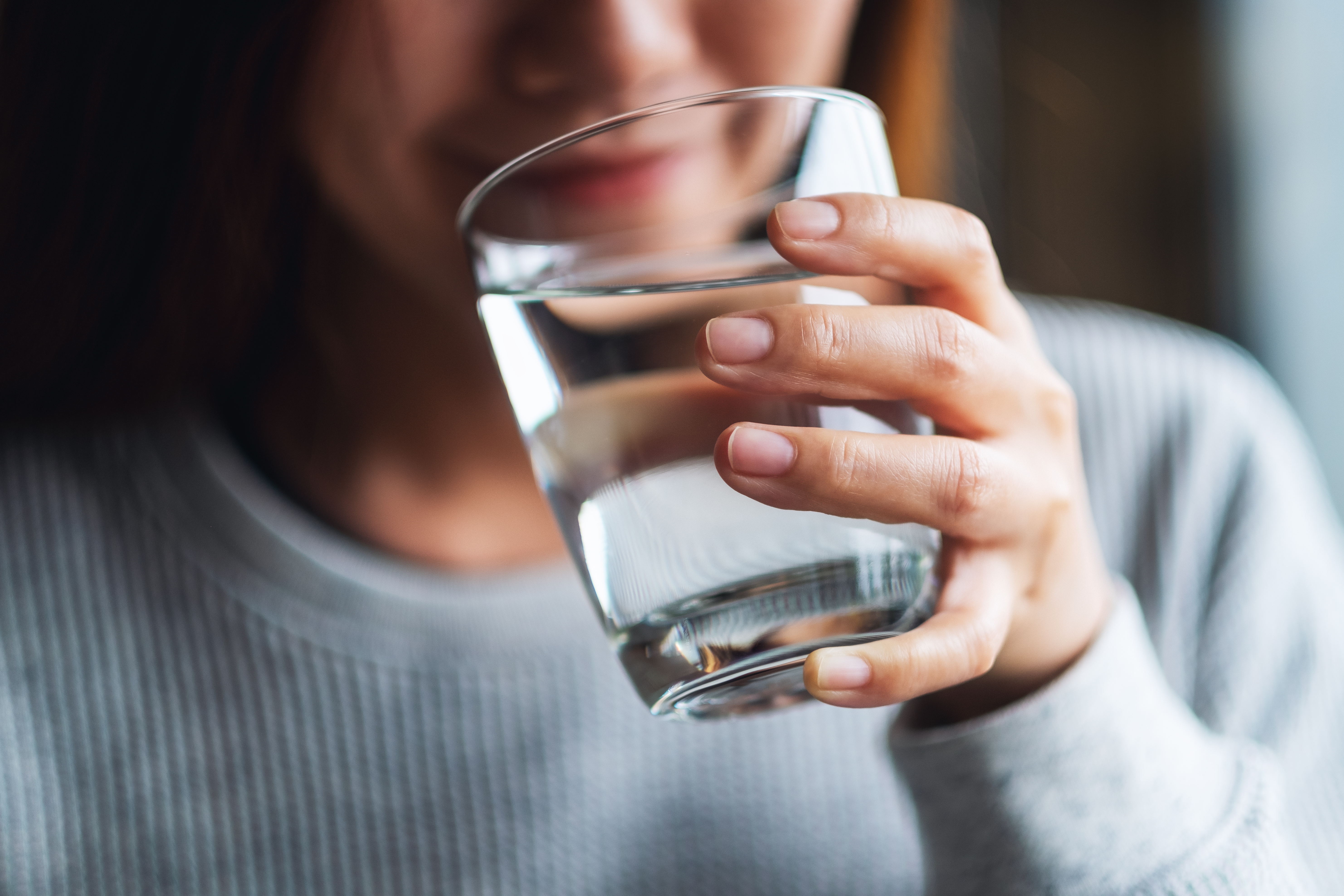 Woman holding glass of drinking water.