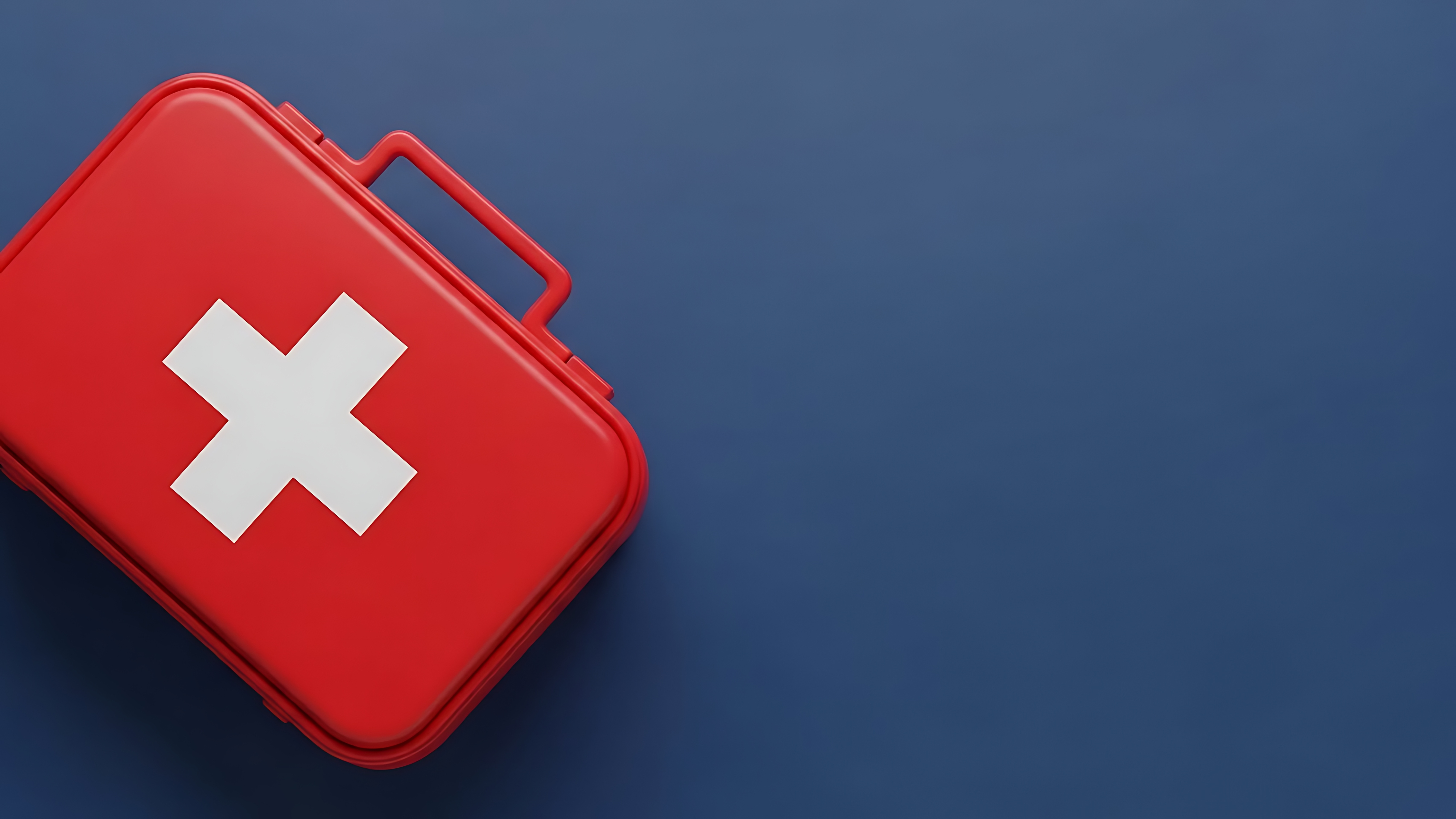 Red first aid kit on dark blue background.