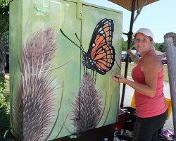 Christine Dexter paints butterfly on mildweed mural
