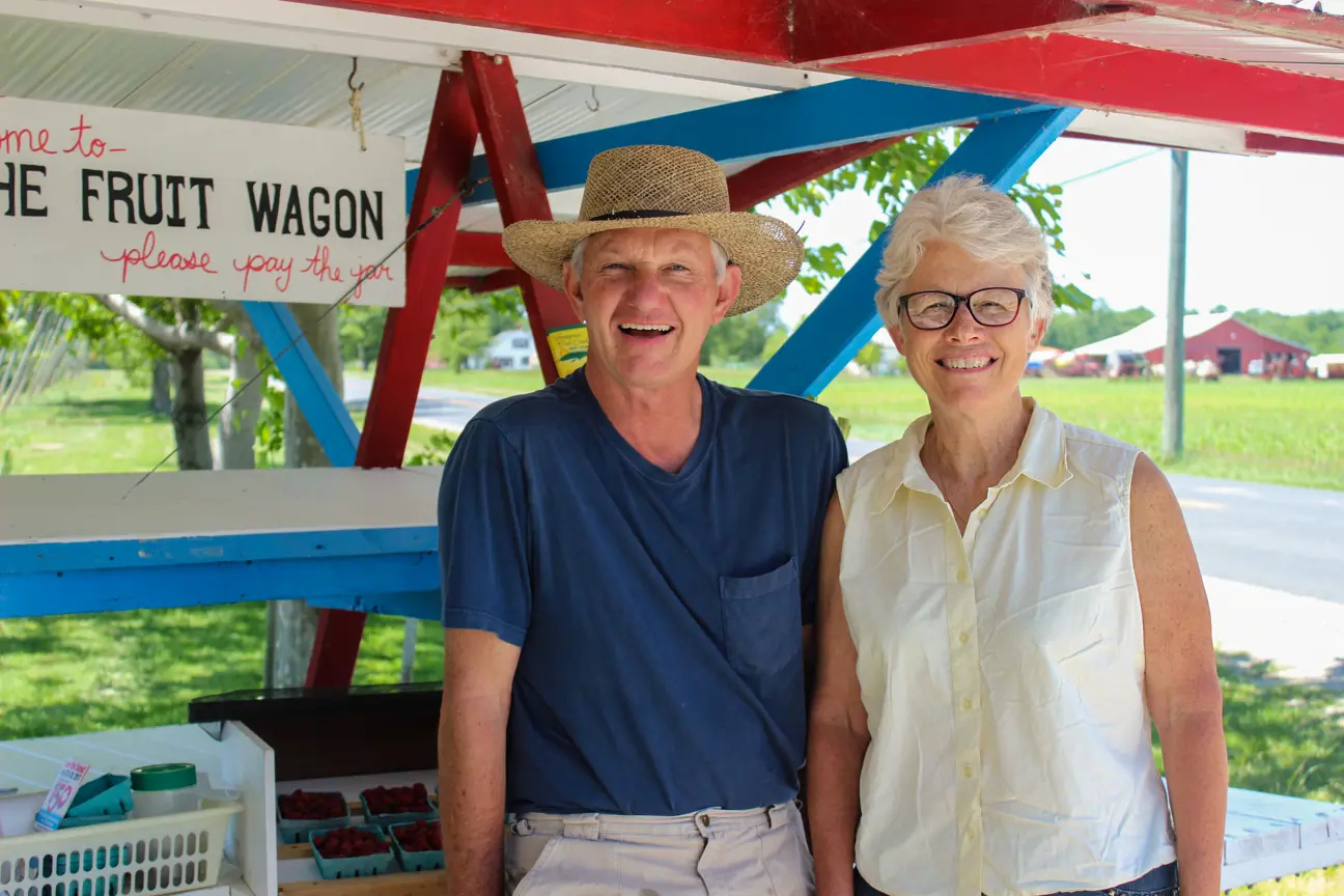 couple standing in front of road side produce stand
