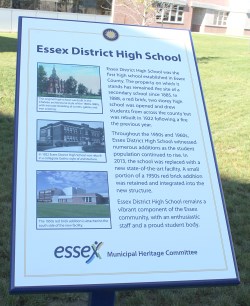 Plaque about Essex District High School staked in the ground in front of school building